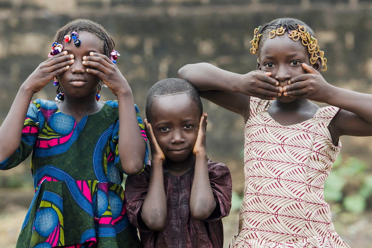 Three different children covering various body parts to reflect social concern.  